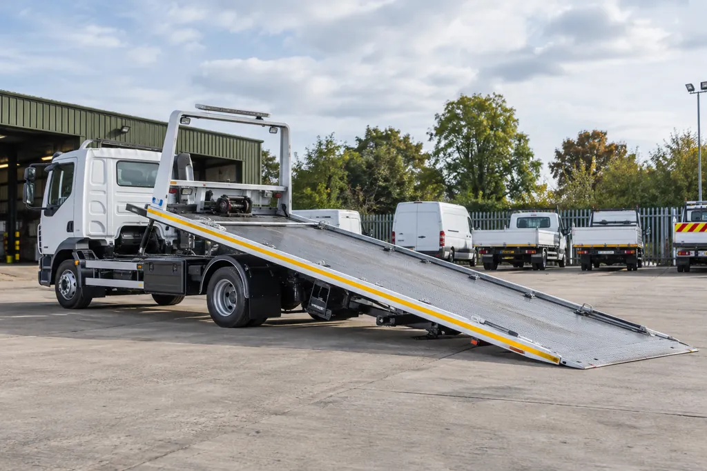A recovery flatbed lowered for loading in a depot